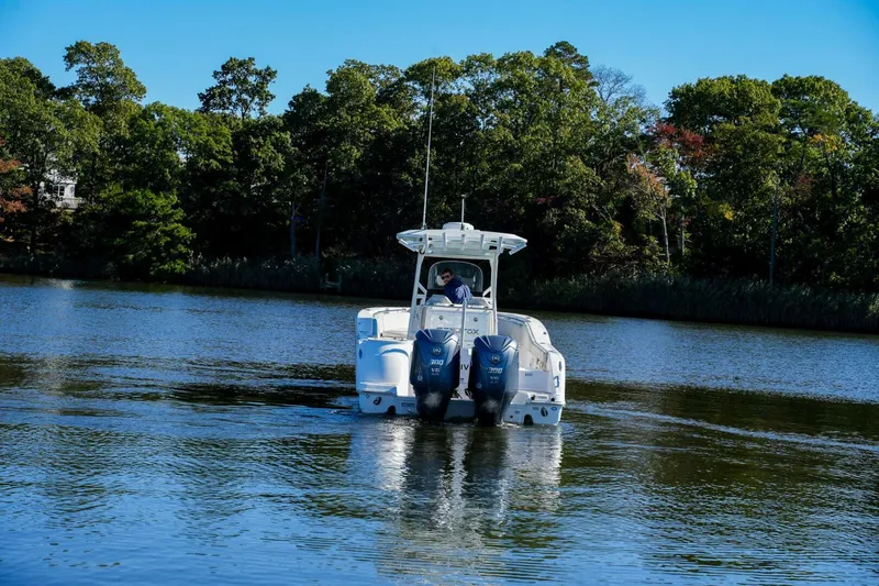  Yacht Photos Pics 2022 Sea Fox 288 Commander boat cruising on a calm lake with forested shoreline.