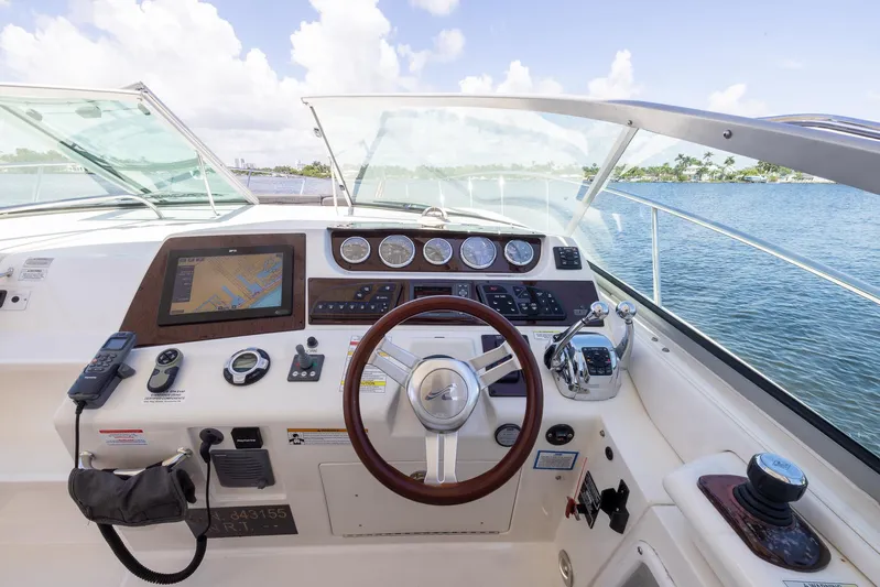 Pura Vida Yacht Photos Pics Cockpit of 2012 Sea Ray 370 Sundancer with steering wheel and navigation controls.