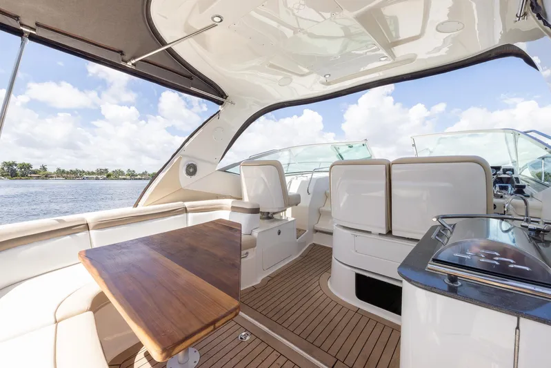 Pura Vida Yacht Photos Pics Luxurious 2012 Sea Ray 370 Sundancer yacht interior with elegant seating and wooden table.