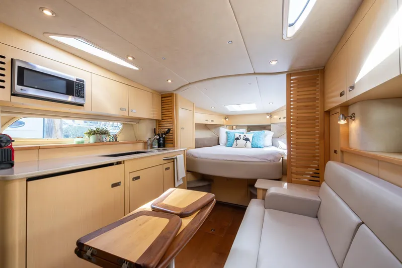 Pura Vida Yacht Photos Pics Luxurious interior of 2012 Sea Ray 370 Sundancer yacht with modern kitchen and cozy bedroom.
