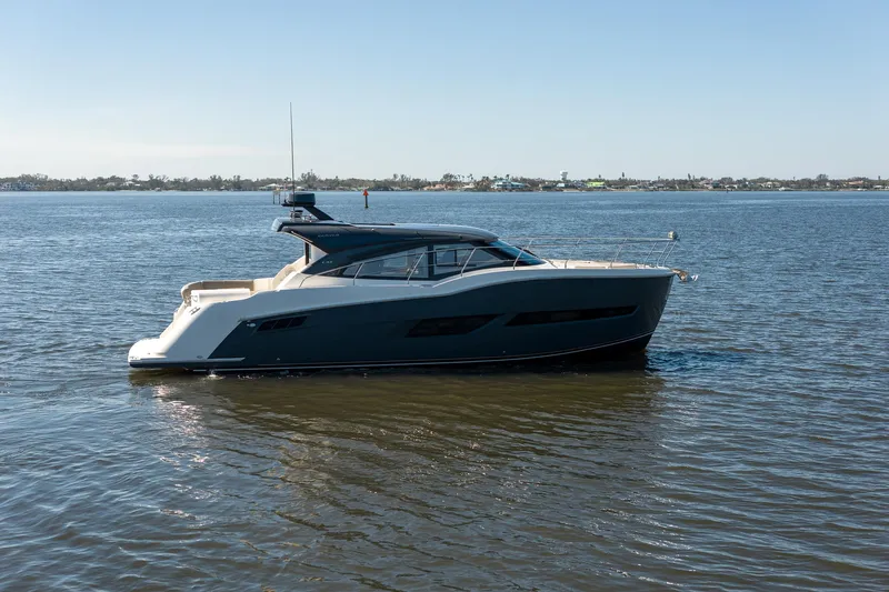 Going Coastal Yacht Photos Pics A sleek 2019 Carver C43 Coupe yacht cruising on calm waters under a clear sky.