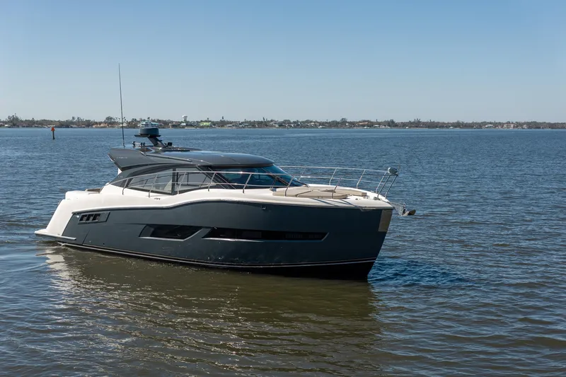 Going Coastal Yacht Photos Pics A sleek 2019 Carver C43 Coupe yacht cruising on calm waters under a clear blue sky.