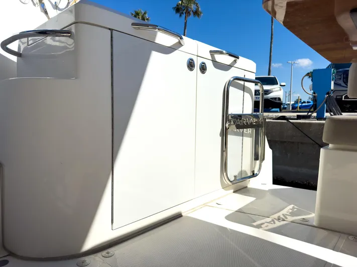 Going Coastal Yacht Photos Pics 2019 Carver C43 Coupe boat deck with storage cabinets and sunny marina backdrop.