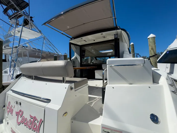 Going Coastal Yacht Photos Pics Rear view of a 2019 Carver C43 Coupe yacht docked at a marina.