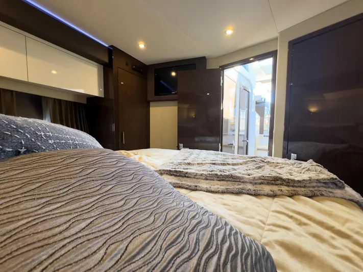 Going Coastal Yacht Photos Pics Luxurious interior of a 2019 Carver C43 Coupe, featuring a cozy bedroom with modern decor.