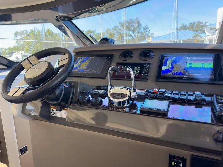 Going Coastal Yacht Photos Pics Modern boat cockpit with advanced navigation screens and controls, featuring a sleek steering wheel.