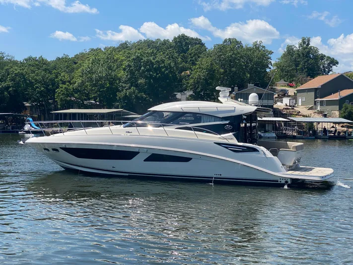  Yacht Photos Pics 2015 Sea Ray 470 Sundancer yacht on a sunny lake, surrounded by trees and houses.