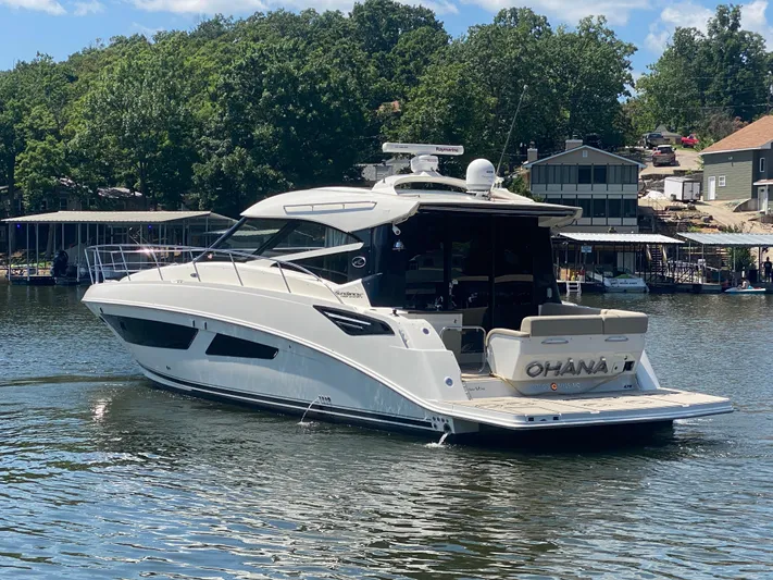  Yacht Photos Pics 2015 Sea Ray 470 Sundancer yacht on a lake, surrounded by trees and houses.