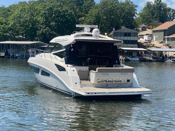  Yacht Photos Pics 2015 Sea Ray 470 Sundancer yacht on a serene lake with lush greenery.