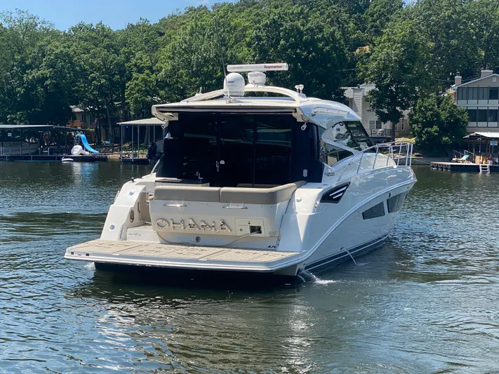 Yacht Photos Pics 2015 Sea Ray 470 Sundancer yacht on a sunny lake, surrounded by trees and docks.