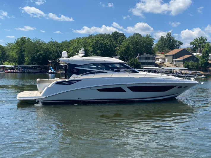 Yacht Photos Pics 2015 Sea Ray 470 Sundancer yacht on a sunny lake with trees and houses in the background.