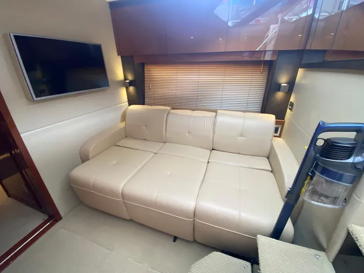  Yacht Photos Pics Luxurious interior of 2015 Sea Ray 470 Sundancer with beige leather sofa and wall-mounted TV.