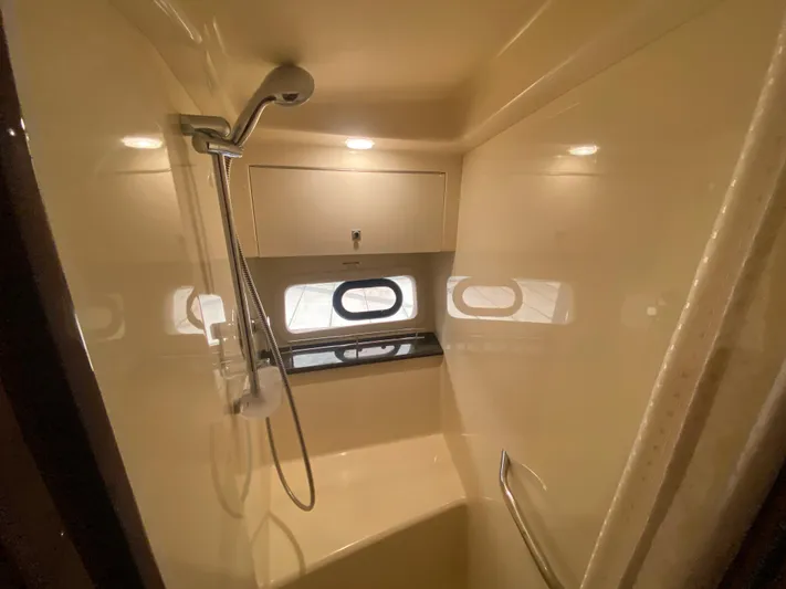  Yacht Photos Pics Shower area in 2015 Sea Ray 470 Sundancer yacht, featuring modern fixtures and porthole windows.