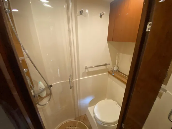  Yacht Photos Pics 2015 Sea Ray 470 Sundancer bathroom with shower, toilet, and wooden cabinetry.