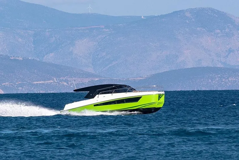  Yacht Photos Pics 2025 Makai M37 boat cruising on blue ocean with mountainous backdrop.