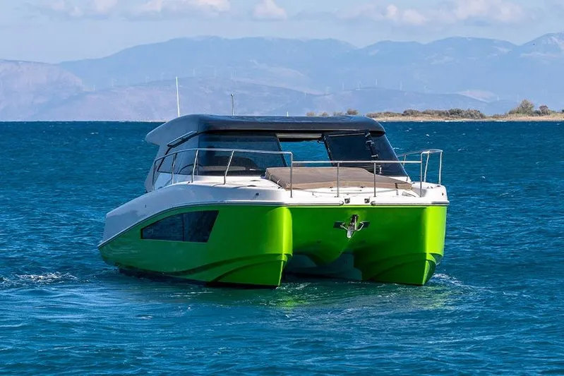  Yacht Photos Pics 2025 Makai M37 catamaran with green hull on blue ocean waters.