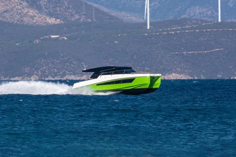  Yacht Photos Pics 2025 Makai M37 boat cruising on blue ocean with mountainous backdrop.