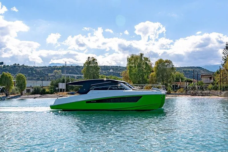  Yacht Photos Pics 2025 Makai M37 yacht cruising on a sunny day, vibrant green hull, scenic background.