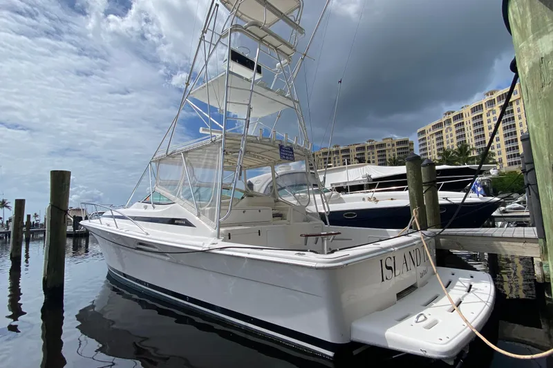 Island Time Yacht Photos Pics Riviera 4000 yacht from 2000 docked at marina under cloudy sky.