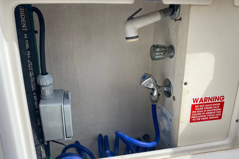Island Time Yacht Photos Pics Boat utility compartment with hoses and warning label, Riviera 4000, year 2000.