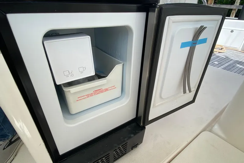 Island Time Yacht Photos Pics Open refrigerator on Riviera 4000 yacht, showcasing ice maker and storage compartment.