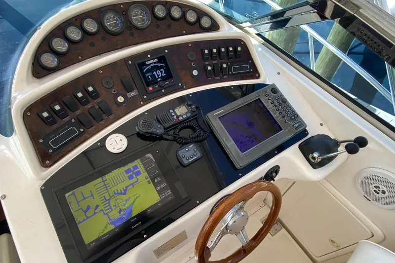 Island Time Yacht Photos Pics Control panel of a 2000 Riviera 4000 boat with navigation equipment and steering wheel.