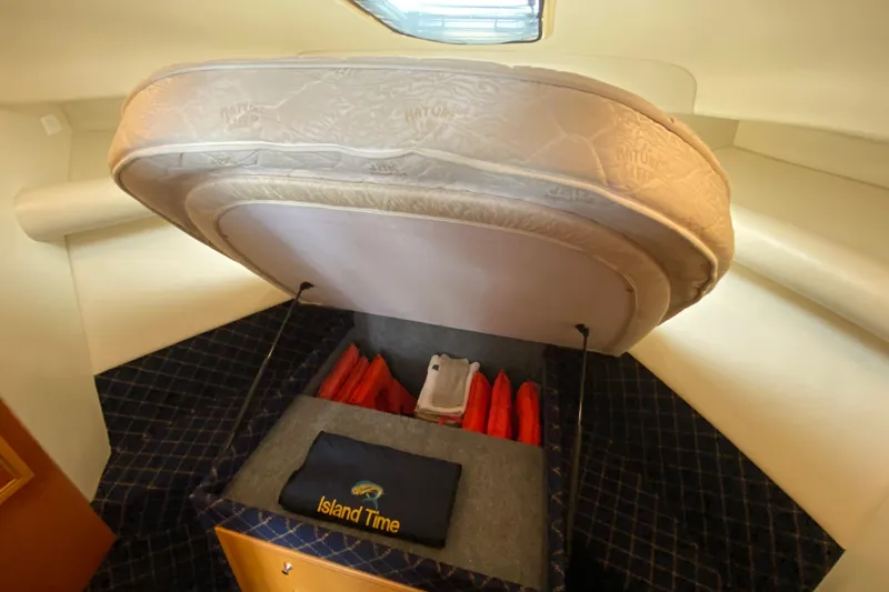 Island Time Yacht Photos Pics Under-bed storage in 2000 Riviera 4000 boat, featuring life jackets and "Island Time" towel.