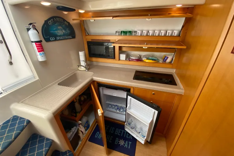 Island Time Yacht Photos Pics Compact kitchen in 2000 Riviera 4000 boat with sink, fridge, and microwave.