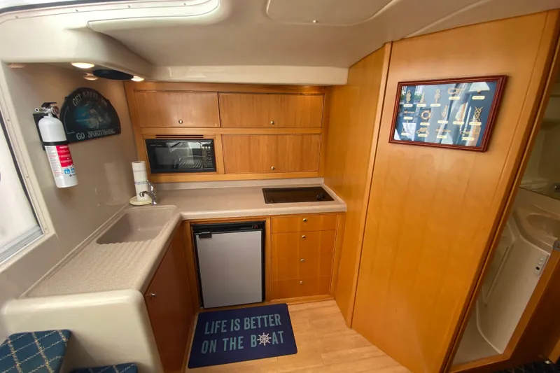 Island Time Yacht Photos Pics Interior of a 2000 Riviera 4000 yacht kitchen with wood cabinetry and modern appliances.