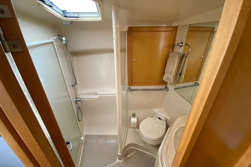 Island Time Yacht Photos Pics Bathroom interior of 2000 Riviera 4000 yacht with shower, toilet, and wooden cabinets.