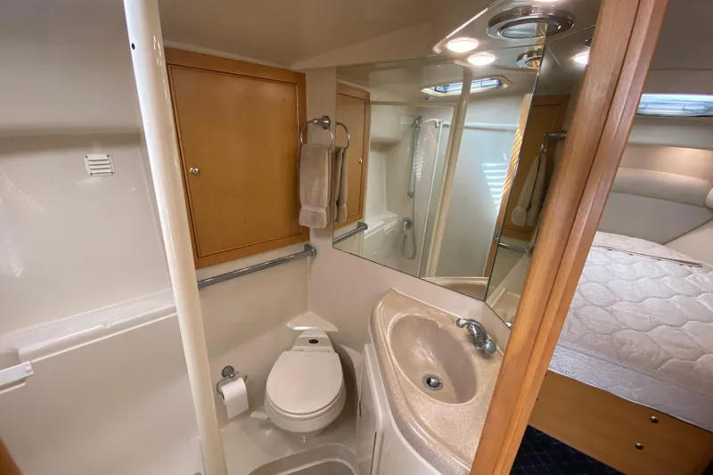 Island Time Yacht Photos Pics Compact bathroom in 2000 Riviera 4000 yacht with sink, toilet, and shower.