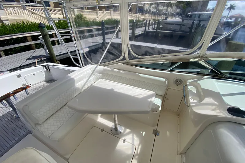 Island Time Yacht Photos Pics 2000 Riviera 4000 yacht interior with white seating and table, docked at marina.