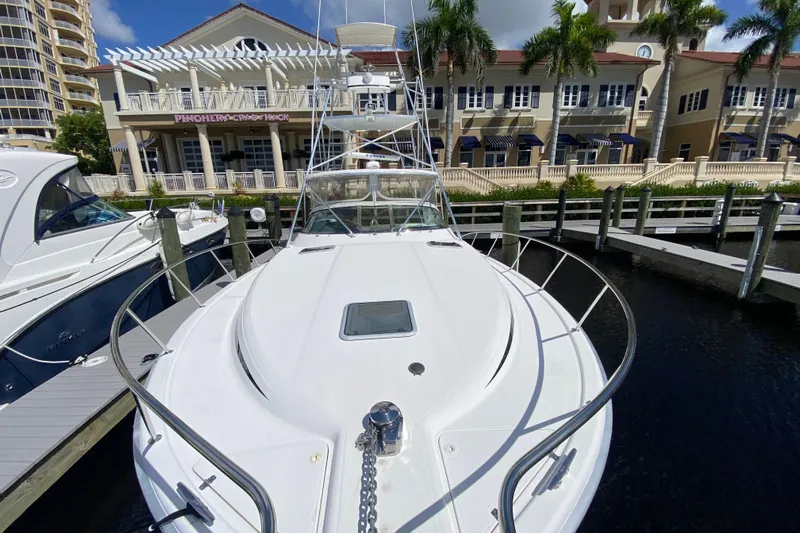 Island Time Yacht Photos Pics Riviera 4000 yacht docked at marina, showcasing sleek design and waterfront buildings.