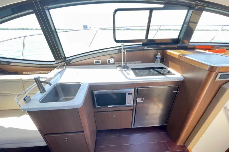  Yacht Photos Pics 2017 Sea Ray Sundancer 400 yacht kitchen with sink, stove, microwave, and scenic window view.