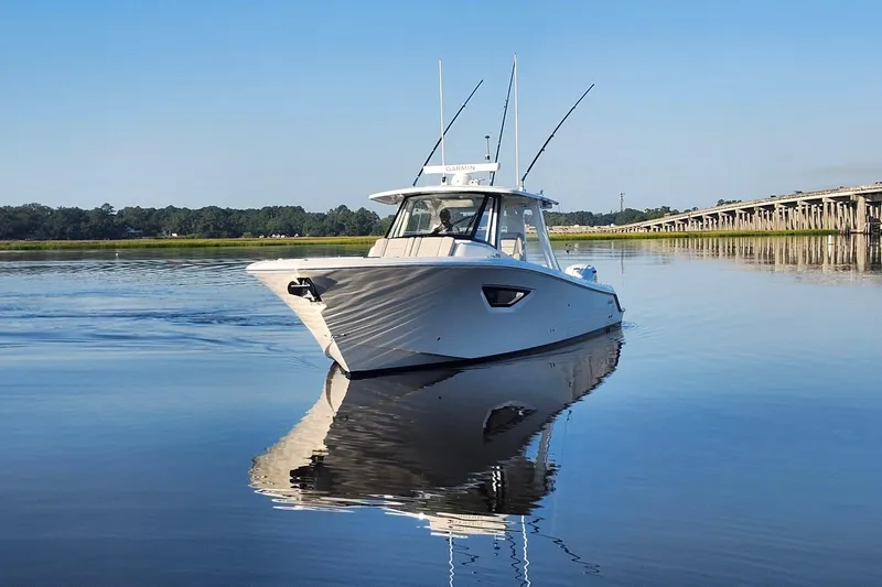  Yacht Photos Pics 2023 Pursuit S 378 Sport boat on calm water near a bridge.