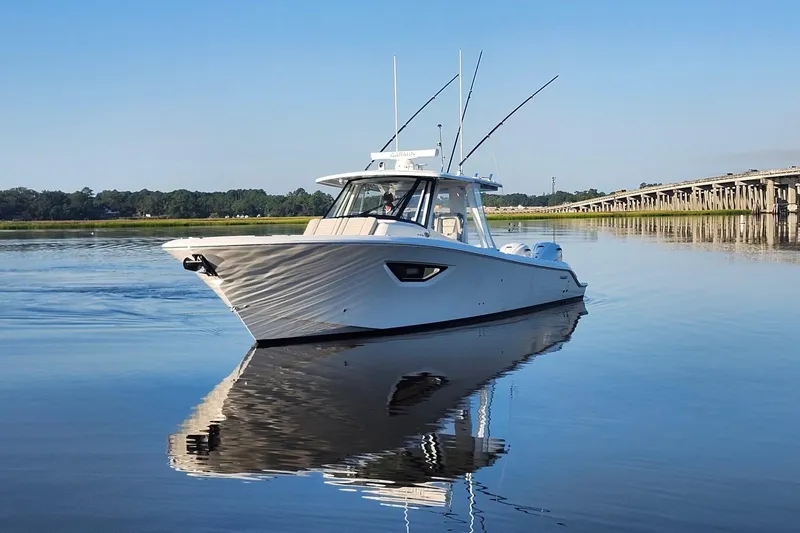  Yacht Photos Pics 2023 Pursuit S 378 Sport boat on calm water near a bridge.