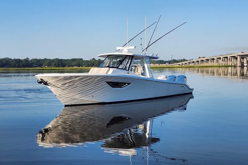  Yacht Photos Pics 2023 Pursuit S 378 Sport boat on calm water near a bridge.
