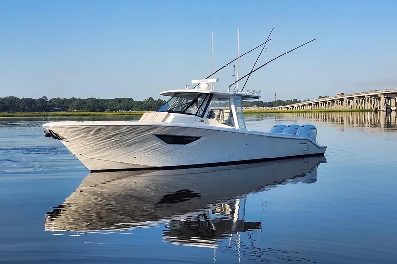  Yacht Photos Pics 2023 Pursuit S 378 Sport boat on calm water near a bridge.