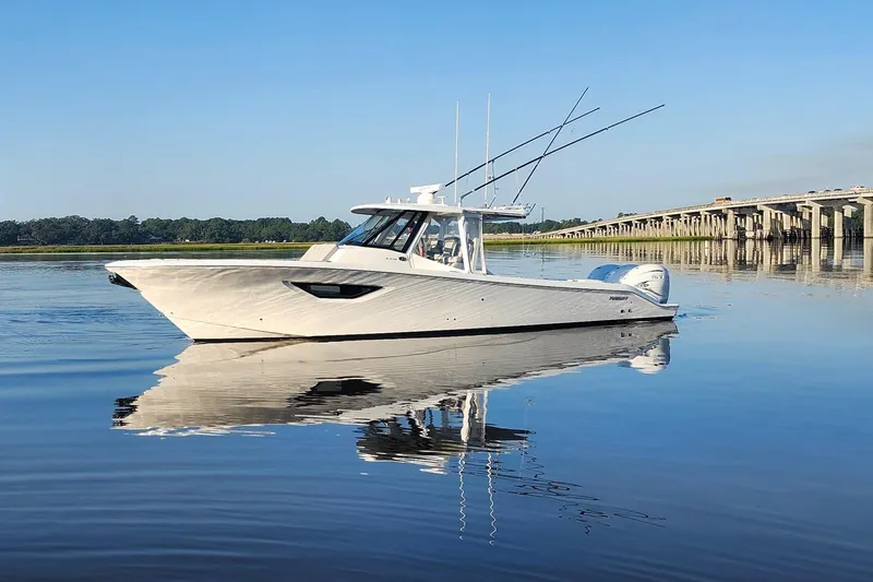  Yacht Photos Pics 2023 Pursuit S 378 Sport boat on calm water near a bridge.