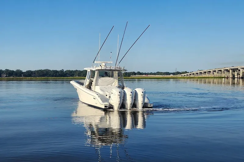  Yacht Photos Pics 2023 Pursuit S 378 Sport boat on calm water near a bridge.