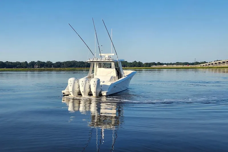  Yacht Photos Pics 2023 Pursuit S 378 Sport boat cruising on calm water under clear blue sky.