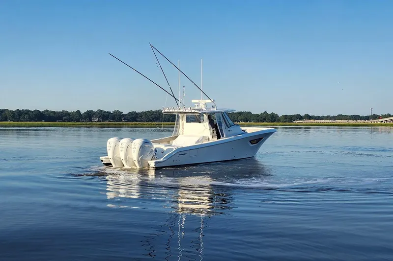  Yacht Photos Pics 2023 Pursuit S 378 Sport boat cruising on calm water under clear blue sky.