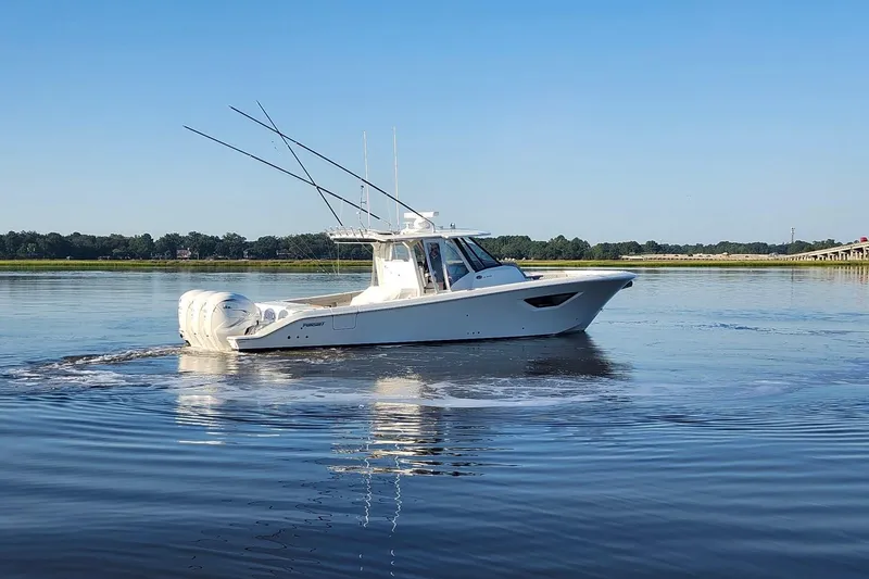  Yacht Photos Pics 2023 Pursuit S 378 Sport boat cruising on calm water under clear blue sky.