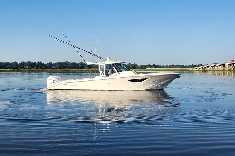  Yacht Photos Pics 2023 Pursuit S 378 Sport boat cruising on calm water under clear blue sky.