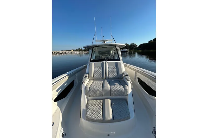  Yacht Photos Pics 2023 Pursuit S 378 Sport boat with luxurious seating on calm water.