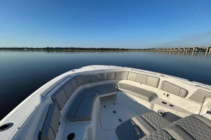  Yacht Photos Pics 2023 Pursuit S 378 Sport boat interior with luxurious seating on calm water.