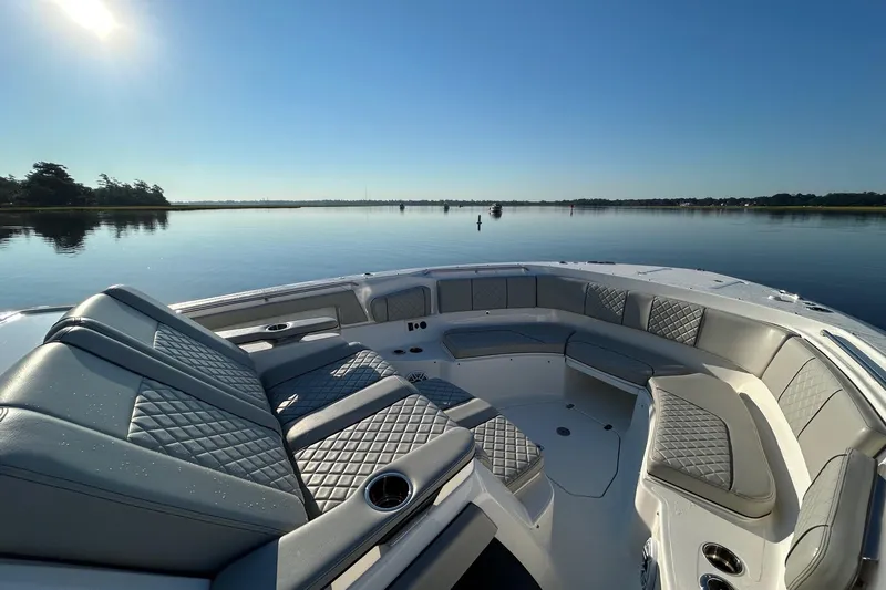  Yacht Photos Pics 2023 Pursuit S 378 Sport boat interior with luxurious seating on calm water.