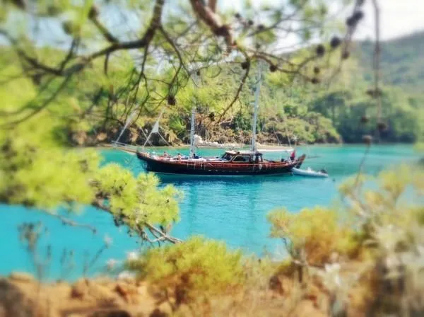 Trİppİn Yacht Photos Pics A 2006 custom wooden ketch Tirhandil 20M anchored in a serene, turquoise bay.