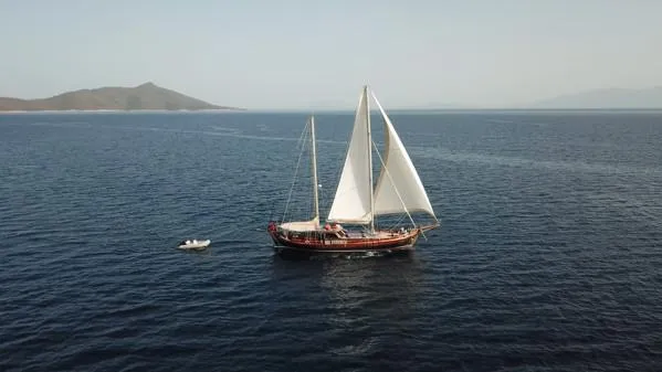 Trİppİn Yacht Photos Pics Wooden Ketch Tirhandil 20M sailing on open sea, 2006 model, with distant hills in background.