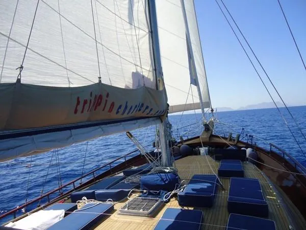 Trİppİn Yacht Photos Pics Wooden Ketch Tirhandil 20M sailing on open sea, 2006 model, with blue cushions on deck.